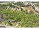 A suburban home surrounded by lush green trees, with commercial buildings in the distance at 6435 Philips Creek Dr, Cumming, GA 30041