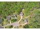 Aerial shot displays a suburban home nestled within a verdant neighborhood with circular driveway entrances at 6435 Philips Creek Dr, Cumming, GA 30041