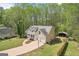 Aerial view of a two story home with a shed, driveway, and mature tree surroundings at 6435 Philips Creek Dr, Cumming, GA 30041