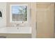 Bright bathroom features large window over soaking tub and tiled shower stall, creating a relaxing space at 6435 Philips Creek Dr, Cumming, GA 30041