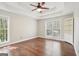 Bright bedroom with hardwood floors, ceiling fan, and windows overlooking the trees at 6435 Philips Creek Dr, Cumming, GA 30041