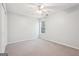 This bedroom features neutral carpeting, a ceiling fan, and a window allowing plenty of natural light at 6435 Philips Creek Dr, Cumming, GA 30041