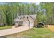 Home exterior featuring a 2 car garage, driveway, large yard, and mature trees at 6435 Philips Creek Dr, Cumming, GA 30041
