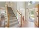 Inviting foyer boasts hardwood floors, staircase with carpet, and a view into the living spaces at 6435 Philips Creek Dr, Cumming, GA 30041