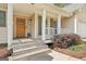 Charming front porch with wooden door, white columns, and well-maintained landscaping adding curb appeal at 6435 Philips Creek Dr, Cumming, GA 30041