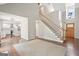 Open-concept living space showcasing a staircase, hardwood floors, and a view into the modern kitchen at 6435 Philips Creek Dr, Cumming, GA 30041