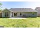 Backyard showcasing the house and grassy area with a patio at 6844 Saganaw Dr, Rex, GA 30273