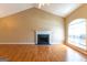 Living room with fireplace, vaulted ceiling, fan, and wood flooring at 6844 Saganaw Dr, Rex, GA 30273