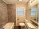 A full bathroom featuring a tub, tile surround, granite countertop vanity and wood look flooring at 1089 Canal St, Decatur, GA 30032