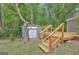 Backyard featuring a wooden deck, shed, and stairs, surrounded by mature trees and a well-maintained lawn at 322 Wood Rdg, Peachtree City, GA 30269