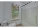 Bright bathroom with a window over a bathtub, featuring tiled walls and a toilet at 322 Wood Rdg, Peachtree City, GA 30269