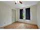 Bright bedroom with hardwood flooring, a ceiling fan, a window with dark curtains, and a closet at 322 Wood Rdg, Peachtree City, GA 30269