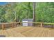 New wooden deck perfect for outdoor entertaining, surrounded by lush trees and a storage shed in the backyard at 322 Wood Rdg, Peachtree City, GA 30269