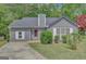 Charming single story home with a well-manicured lawn, beautiful landscaping, and a gray exterior at 322 Wood Rdg, Peachtree City, GA 30269