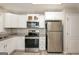 Modern kitchen with white cabinets, stainless steel appliances, and granite countertops at 7161 Bowie Dr, Lithonia, GA 30038