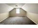 Finished attic with gray carpet, paneled walls, and window at 2361 Whites Mill Rd, Decatur, GA 30032
