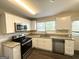 Modern kitchen features stainless steel appliances, white cabinets, granite countertops, and a window for natural light at 2361 Whites Mill Rd, Decatur, GA 30032