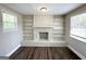Inviting living area with a white brick fireplace, built-in shelves, dark floors, and natural light from two windows at 2361 Whites Mill Rd, Decatur, GA 30032