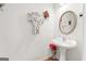 Charming powder room features a pedestal sink, decorative mirror, and stylish floral accents at 3156 Oak Ridge Ln, Loganville, GA 30052