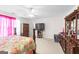 Bedroom with ceiling fan, large window, plush carpet, and dark wood furniture at 3156 Oak Ridge Ln, Loganville, GA 30052