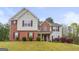 Two-story home featuring a mix of brick and siding, complemented by red shutters and manicured landscaping at 3156 Oak Ridge Ln, Loganville, GA 30052