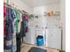Practical laundry room equipped with a washer, dryer, utility sink, and shelving for organized storage at 3156 Oak Ridge Ln, Loganville, GA 30052