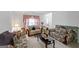 Cozy living room with three plush sofas, complemented by floral arrangements and natural light at 3156 Oak Ridge Ln, Loganville, GA 30052
