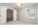 This room is a bedroom featuring neutral walls, carpeted floors, and natural light from the window at 5082 Highland Hills Ct # 93, Stone Mountain, GA 30088