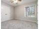 A bright bedroom featuring plush carpet, a ceiling fan, and a window with blinds at 5082 Highland Hills Ct # 93, Stone Mountain, GA 30088