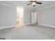 This is a carpeted bedroom featuring neutral walls, modern ceiling fan and a view to an ensuite bathroom at 5082 Highland Hills Ct # 93, Stone Mountain, GA 30088