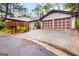 Charming home featuring a two-car garage and a well-maintained interlocking brick driveway, set amidst lush greenery at 5082 Highland Hills Ct # 93, Stone Mountain, GA 30088