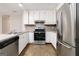 Eat-in kitchen featuring stainless steel appliances, updated countertops, and white cabinetry at 5082 Highland Hills Ct # 93, Stone Mountain, GA 30088