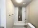 Bright bathroom featuring tiled tub with modern fixtures and white tile at 3191 Gay Dr, Decatur, GA 30032