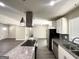 Well-equipped kitchen featuring an island cooktop, modern range hood, and stainless steel appliances at 3191 Gay Dr, Decatur, GA 30032