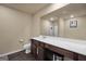 Bathroom featuring dark wood vanity with a large mirror, vinyl flooring, and toilet at 157 Oliver Dr, Locust Grove, GA 30248