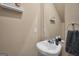 Powder room featuring a pedestal sink, floating shelf, and modern fixtures at 157 Oliver Dr, Locust Grove, GA 30248