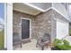 Covered entryway with seating area, brick and stone facade, leading to the home's entrance at 157 Oliver Dr, Locust Grove, GA 30248