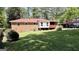 A sprawling backyard with a brick home, red roof, screened in porch, and lush green grass at 1093 Grace Sw St, Mableton, GA 30126