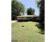 Charming brick ranch home with a well-manicured lawn, mature trees, and a metal roof at 1093 Grace Sw St, Mableton, GA 30126