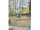 Large backyard with grassy area and a trampoline under the shade of tall trees at 110 S Fairfield Dr, Peachtree City, GA 30269