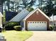 Charming one-story home featuring a well-manicured lawn and a two-car garage with a brick facade at 110 S Fairfield Dr, Peachtree City, GA 30269