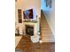 Cozy living room featuring a fireplace, staircase, and hardwood floors at 110 S Fairfield Dr, Peachtree City, GA 30269