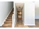 Inviting hallway leading to kitchen, featuring stairs with carpet and neutral wall color at 2554 Willenhall Way, Lithonia, GA 30058