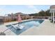 Backyard pool features a sun shelf with loungers and mature landscaping and privacy fence at 155 Lawrence Dr, Villa Rica, GA 30180