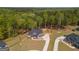Aerial view shows a house with a fenced backyard, a playground, a long driveway and mature trees at 115 W Wind Ct, Tyrone, GA 30290
