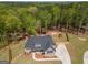 Stunning aerial view of a two-story home, showcasing the landscaped yard, play set, and wooded surroundings at 115 W Wind Ct, Tyrone, GA 30290