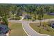 Aerial view of a community with manicured lawns, a lake, and mature trees at 115 W Wind Ct, Tyrone, GA 30290