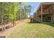 Backyard with spacious multi-level deck, stairways, and play area set against a wooded backdrop at 115 W Wind Ct, Tyrone, GA 30290