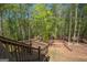 Multi-level yard with mature trees and wooden staircase offers a retreat into a natural landscape at 115 W Wind Ct, Tyrone, GA 30290