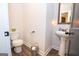 Half bathroom with white toilet, pedestal sink, and wood look floors at 115 W Wind Ct, Tyrone, GA 30290